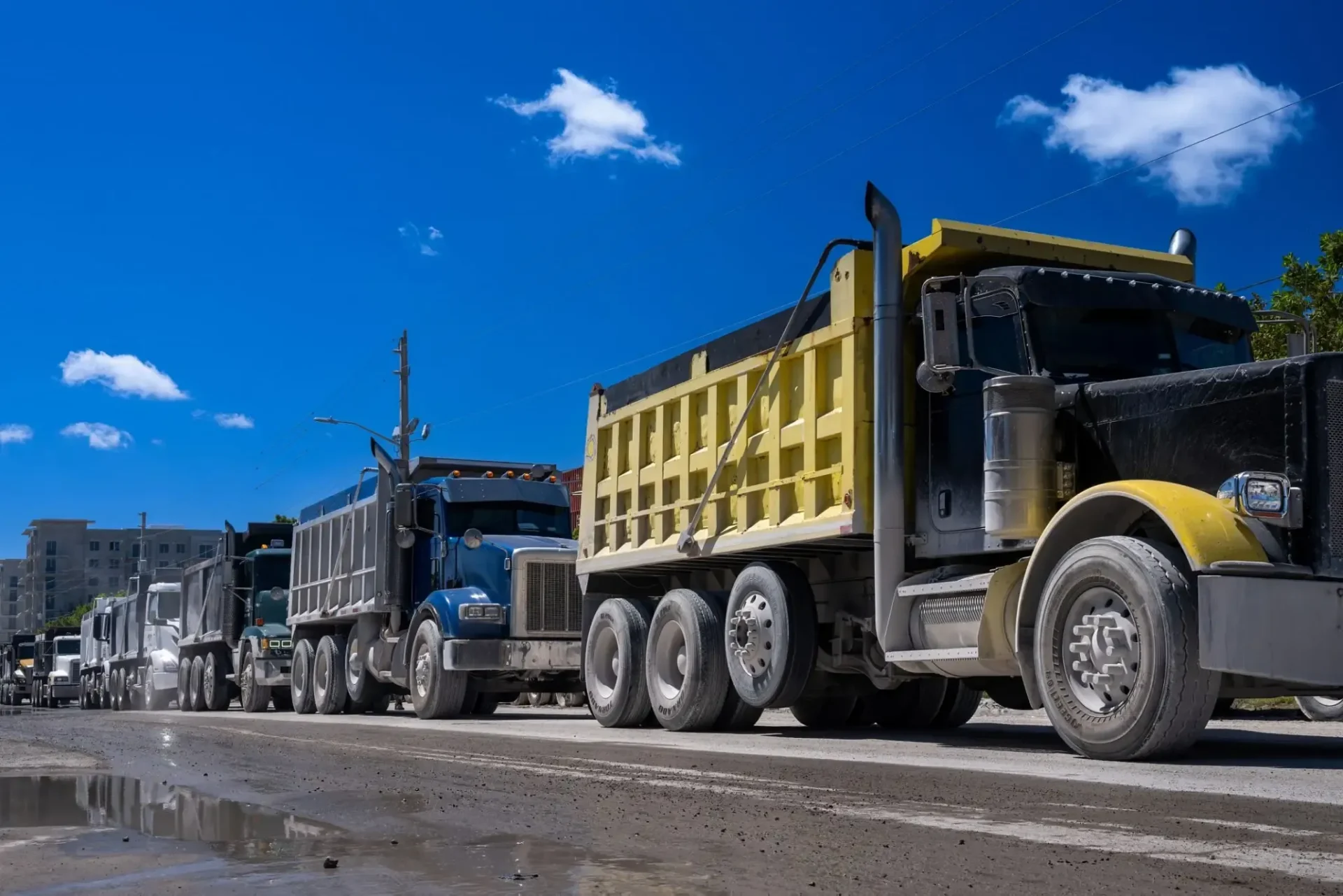 Line of dump trucks on construction road